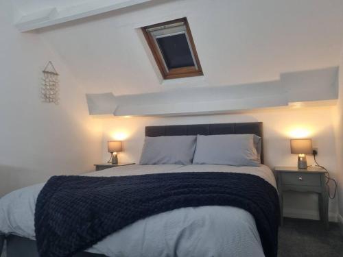 a bedroom with a large bed with two night stands at Cosy Moat House Cottage #6 in Pembroke