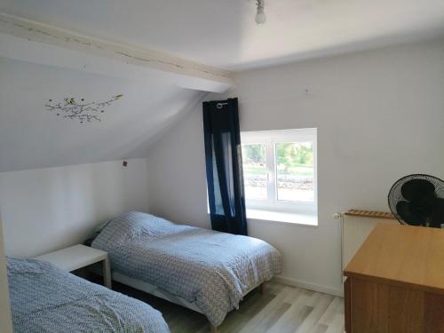 1 Schlafzimmer mit 2 Betten und einem Fenster in der Unterkunft Maison 10 couchages secteur Fontainebleau in Vernou-sur-Seine