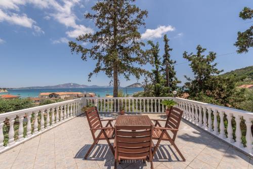 a table and chairs on a balcony with a view of the water at Villa Panorama in Keri