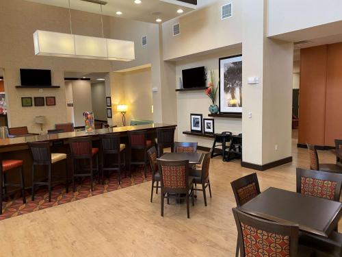 a restaurant with tables and chairs and a bar at Hampton Inn & Suites Tampa Northwest/Oldsmar in Oldsmar