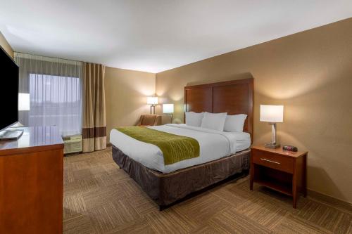 a hotel room with a large bed and a desk at Comfort Inn Collinsville near St Louis in Collinsville
