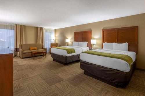 una habitación de hotel con 2 camas y una silla en Comfort Inn Collinsville near St Louis en Collinsville