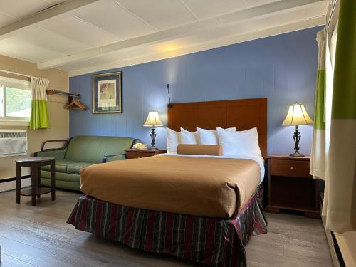 ClaremontにあるClaremont Motor Lodgeのベッドとソファ付きのホテルルーム