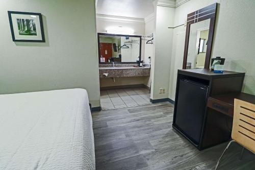 a bedroom with a bed and a bathroom with a sink at Rodeway Inn San Antonio Lackland AFB - SeaWorld in San Antonio