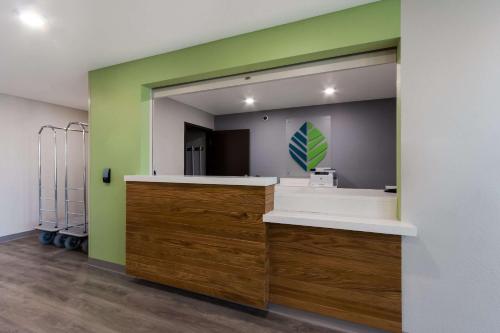 Habitación con baño con espejo y lavabo. en WoodSpring Suites Chandler Airport en Chandler
