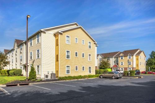 a apartment building with a car parked in a parking lot at MainStay Suites Mt Laurel - Philadelphia in Mount Laurel