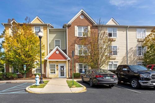 a house with a car parked in a parking lot at MainStay Suites Mt Laurel - Philadelphia in Mount Laurel