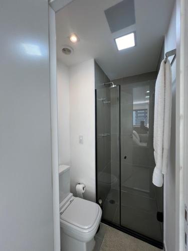 uma casa de banho com um WC e uma cabina de duche em vidro. em Apartamento de luxo em Jardins, Oscar Freire em São Paulo