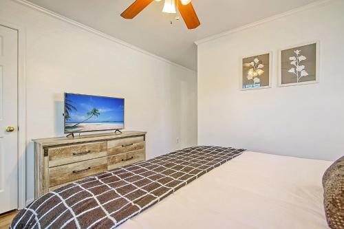 a bedroom with a bed and a tv on a dresser at Cam's Retreat on Apple Street in Charleston