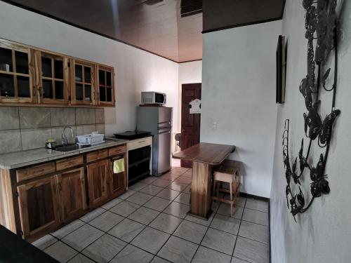 a kitchen with wooden cabinets and a table in it at Cabaña Vista Verde in Cartago