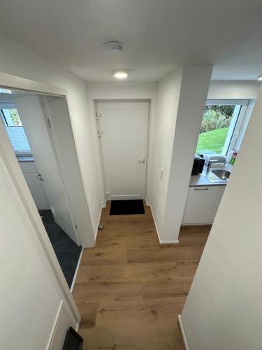 an empty room with a hallway with a door at Modernes Apartment mit eigener Terrasse & Garten in Aalen