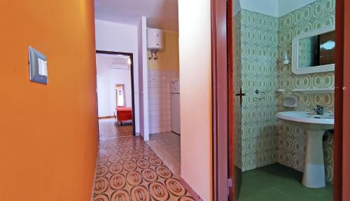 プンタ・セッカにあるResidence Ulisseのオレンジ色のバスルーム(洗面台、トイレ付)