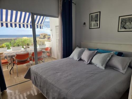 a bedroom with a bed and a view of the ocean at Apartamento Ura in Morro del Jable