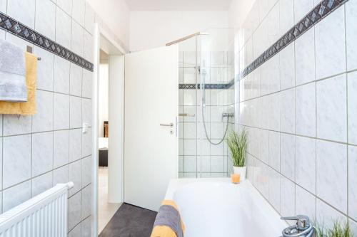 a white bathroom with a tub and a shower at FourSolos Apartment in Central Essen in Essen