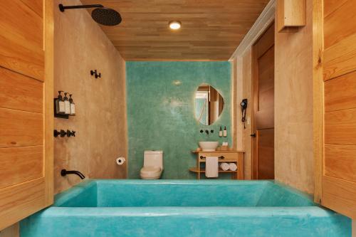 a bathroom with a blue tub in a room at Hotel Materia in Oaxaca City