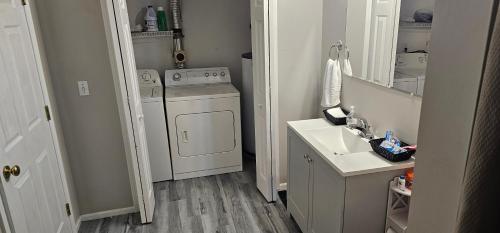 una pequeña cocina con lavadora y fregadero en Southford spacious apartment - Southbury, Connecticut, en Southbury