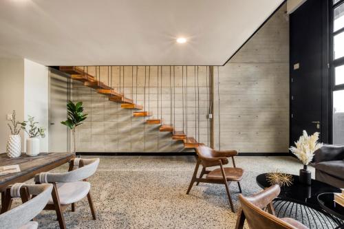 a living room with a staircase and chairs at Downtown Loft by ULIV in Tijuana