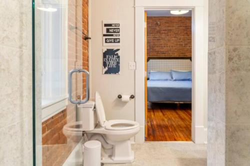 a bathroom with a toilet and a bedroom with a bed at The Marilyn Monroe Loft. Central Downtown Location in Roanoke
