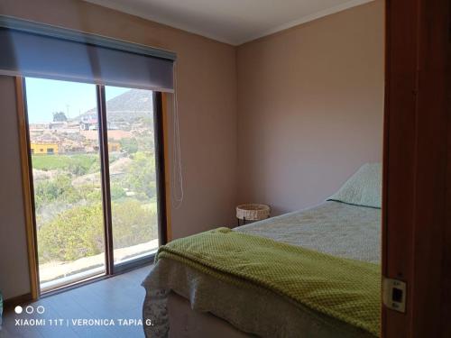 a bedroom with a bed and a large window at Cabaña, quincho, piscina y hermosas estrellas in La Serena