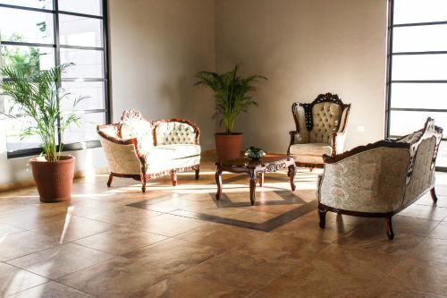a living room with several chairs and a coffee table at Hotel Los Frailes, Valladolid, Yucatán in Valladolid