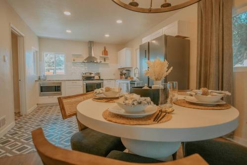 uma cozinha com uma mesa com cadeiras e uma sala de jantar em Casa Urbana-2BD-2BTH-Hot Tub-Pet Friendly-No Pet Fees! em Albuquerque