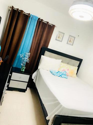 a small bedroom with a bed and a night stand at Hermoso residencial con piscina licey al medio in Licey al Medio