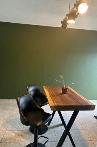uma mesa com duas cadeiras e um vaso de plantas sobre ela em Natural Black em Mérida