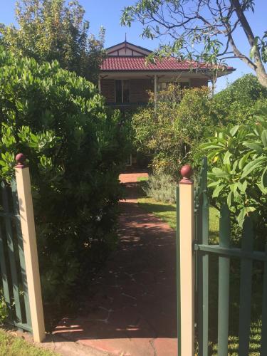 a gate to a house with a garden at Wellness Stay in Private Home near beaches, rainforest and South Coast, 2 rooms booked separately in Dapto