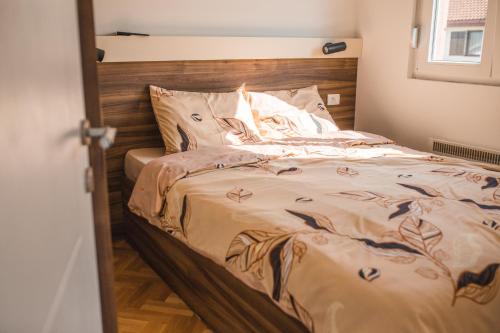 Bett mit einem Kopfteil aus Holz in einem Schlafzimmer in der Unterkunft Sunny Paradise in Vrnjačka Banja