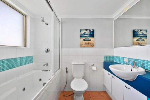 a bathroom with a white toilet and a sink at Whale Point in Yaroomba