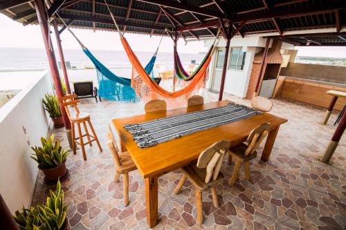 ein Esszimmer mit einem Tisch, Stühlen und Meerblick in der Unterkunft Makena La Boquilla Beach Hostel in Cartagena de Indias