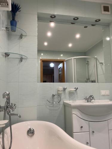 a bathroom with a tub and a sink and a mirror at Apartament Familijny Beskidzki in Ustroń