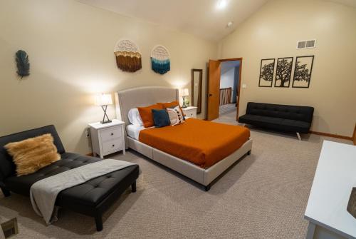 a bedroom with a bed and a couch at Harmony Hill Stylish 4bd Mountain Retreat, Hot Tub, Games in Bushkill