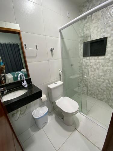 a bathroom with a toilet and a shower and a sink at Dunas Flat in Galinhos