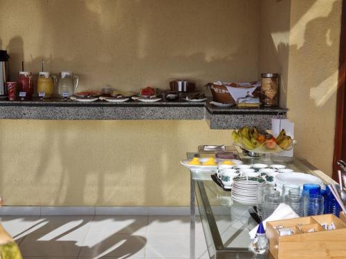 a kitchen with a glass table with food on it at Pousada Talismã in Barreirinhas