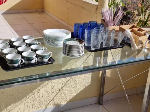 a glass counter with cups and plates on it at Pousada Talismã in Barreirinhas