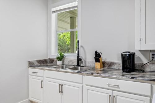 a white kitchen with a sink and a window at Unit 4: Large fully furnished 1 bedroom in Billings