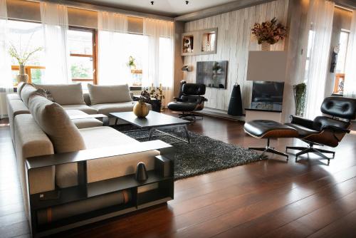 a living room with a large couch and chairs at Sea View Villa in Garðabær