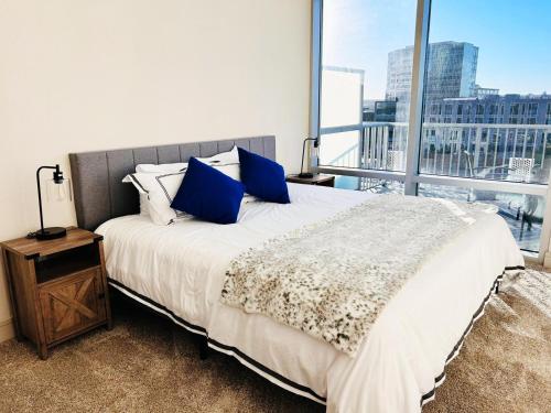 een slaapkamer met een bed met blauwe kussens en een raam bij 1 BR King Bed Downtown Oasis Heart Of Austin in Austin
