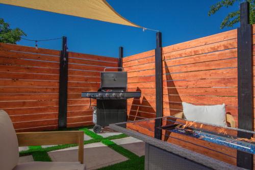 a barbecue grill in a backyard with a fence at Casa Urbana-Close to Downtown-Hot Tub-Pet Friendly-No Pet Fees! in Albuquerque