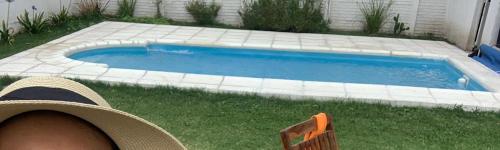 a person sitting in a chair next to a swimming pool at Casa Mali in Azul