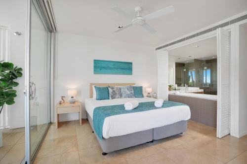- une chambre avec un grand lit et une baignoire dans l'établissement Unit 105 Plantation Resort Rainbow Beach, à Rainbow Beach