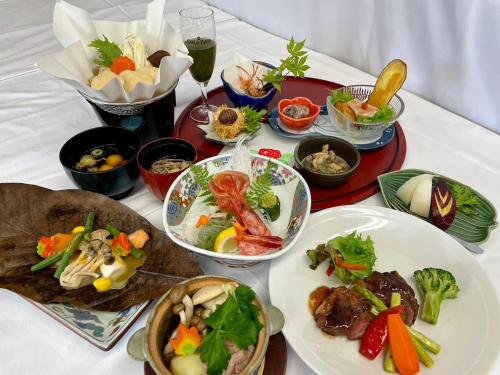 Lake Side Nikko Hotel في نيكو: طاولة مع أطباق من الطعام وأوعية من الطعام
