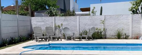 un grupo de sillas sentadas junto a una piscina en Casa Mali en Azul