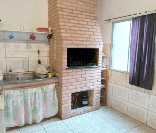 a brick fireplace in a kitchen with a sink at Pousada Central - Prox da Rodoviaria, Shoping Total, Hosp Santa Casa e Presidente Vargas in Porto Alegre