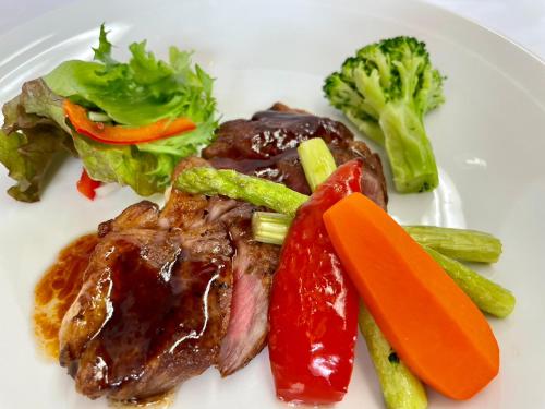 a plate of food with meat and vegetables on it at Lake Side Nikko Hotel in Nikko