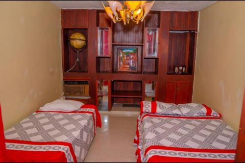 a bedroom with two beds and a chandelier at Villa Eliana in Baní