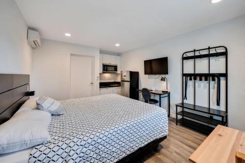 Unik Motel في هاربور سيتي: غرفة نوم صغيرة بها سرير ومطبخ