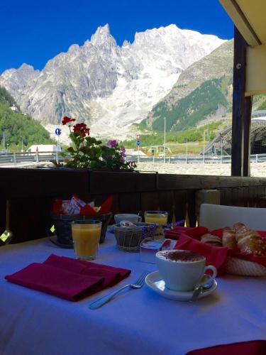 a table with food on it with a view of a mountain at Shatush Hotel in Courmayeur