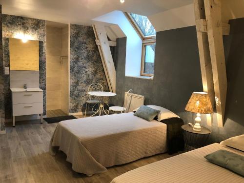 a bedroom with two beds and a table and a window at Gîte de charme proche Le Mans avec jardin, parking, et bien-être - FR-1-410-205 in Coulans-sur-Gée
